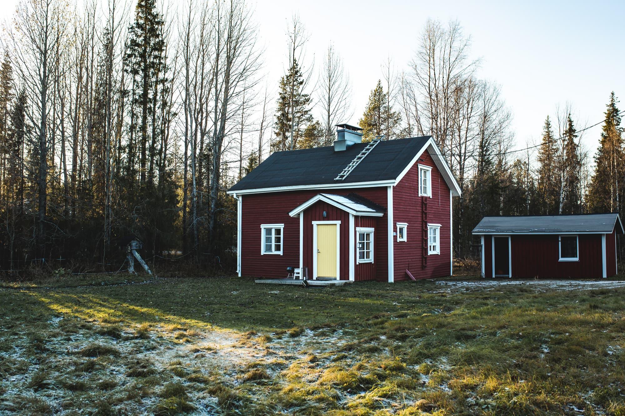Mökki ja piharakennus metsän reunassa