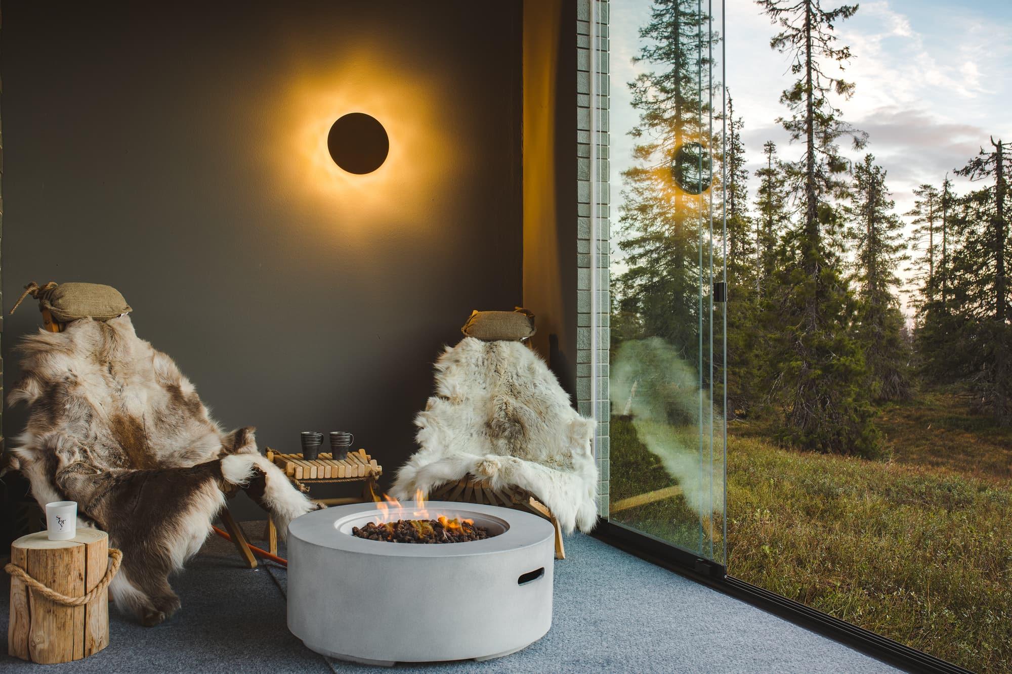 Glazed terrace with outdoor fireplace and forest view
