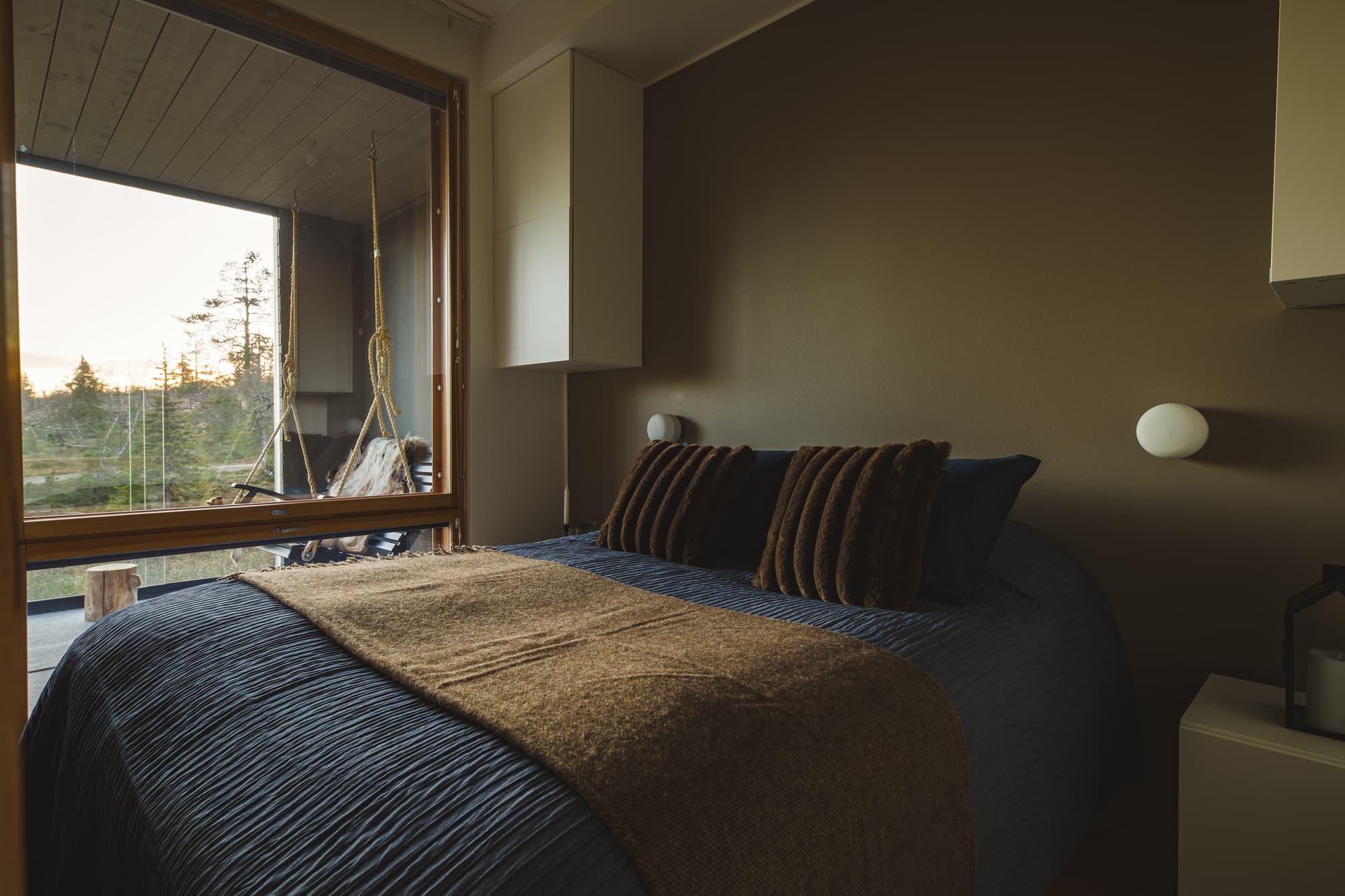 Bedroom with double bed and window to the forest